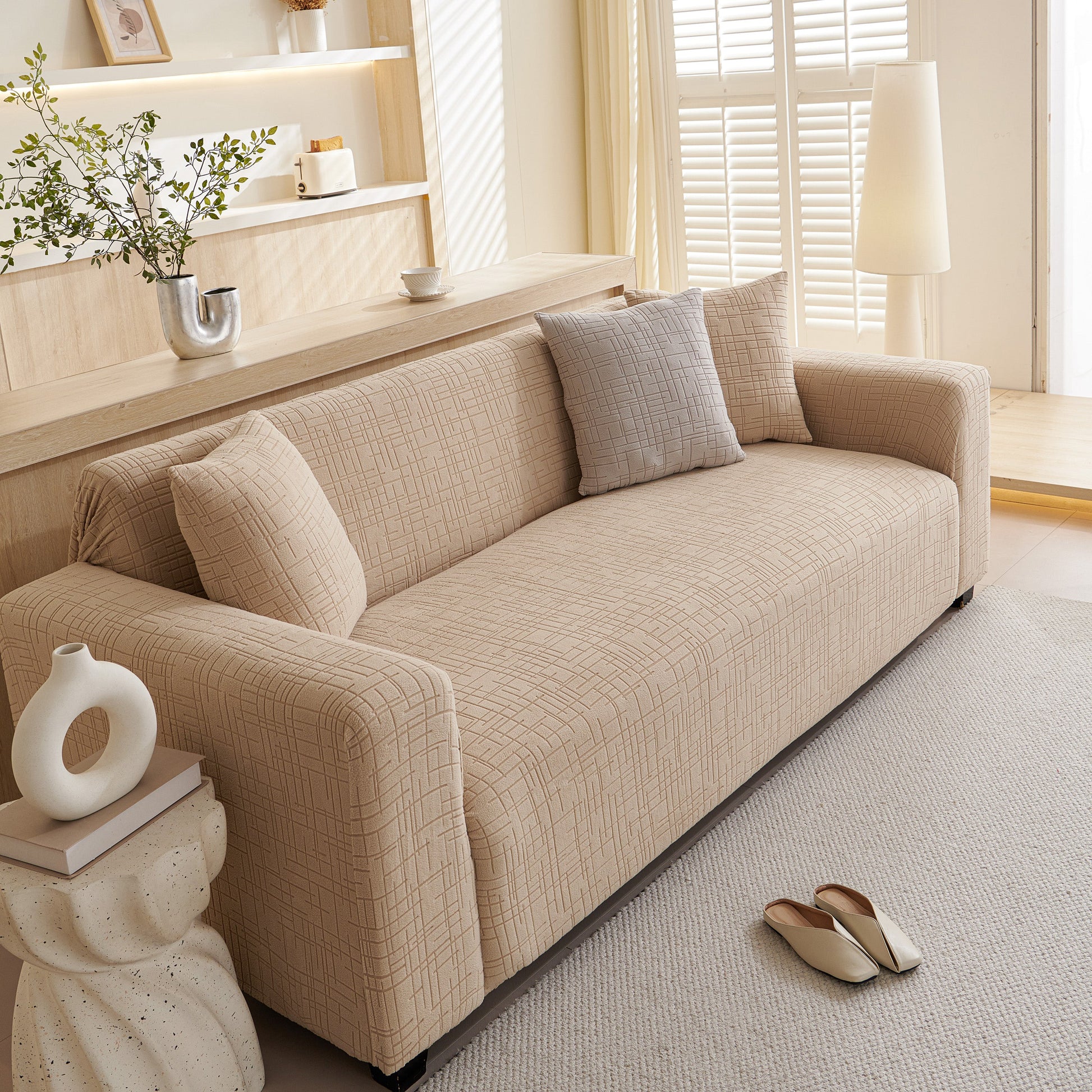 Cozy living room with embossed lines couch cover, stretchable non-slip & washable sofa slipcovers on a beige couch.