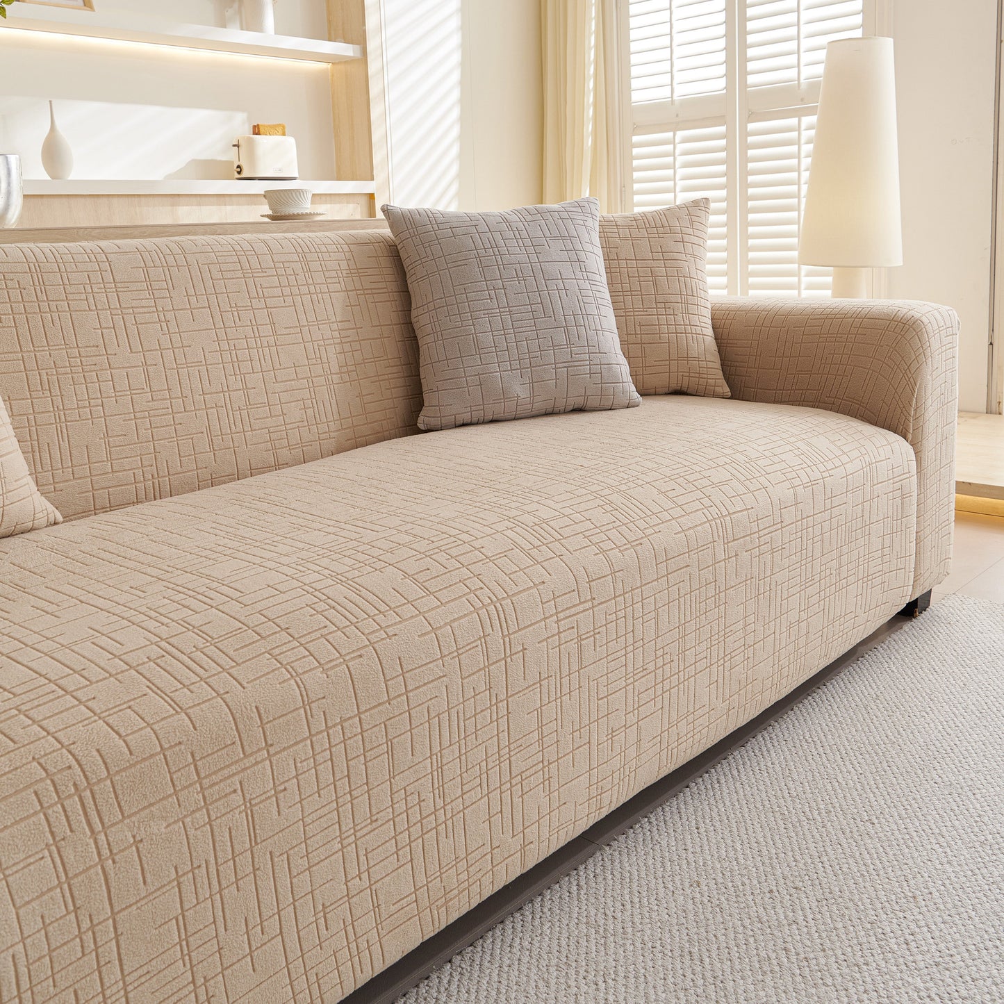 Embossed Lines Couch Covers Stretchable Non-Slip & Washable Sofa Slipcovers in beige on a modern sofa in a bright living room.