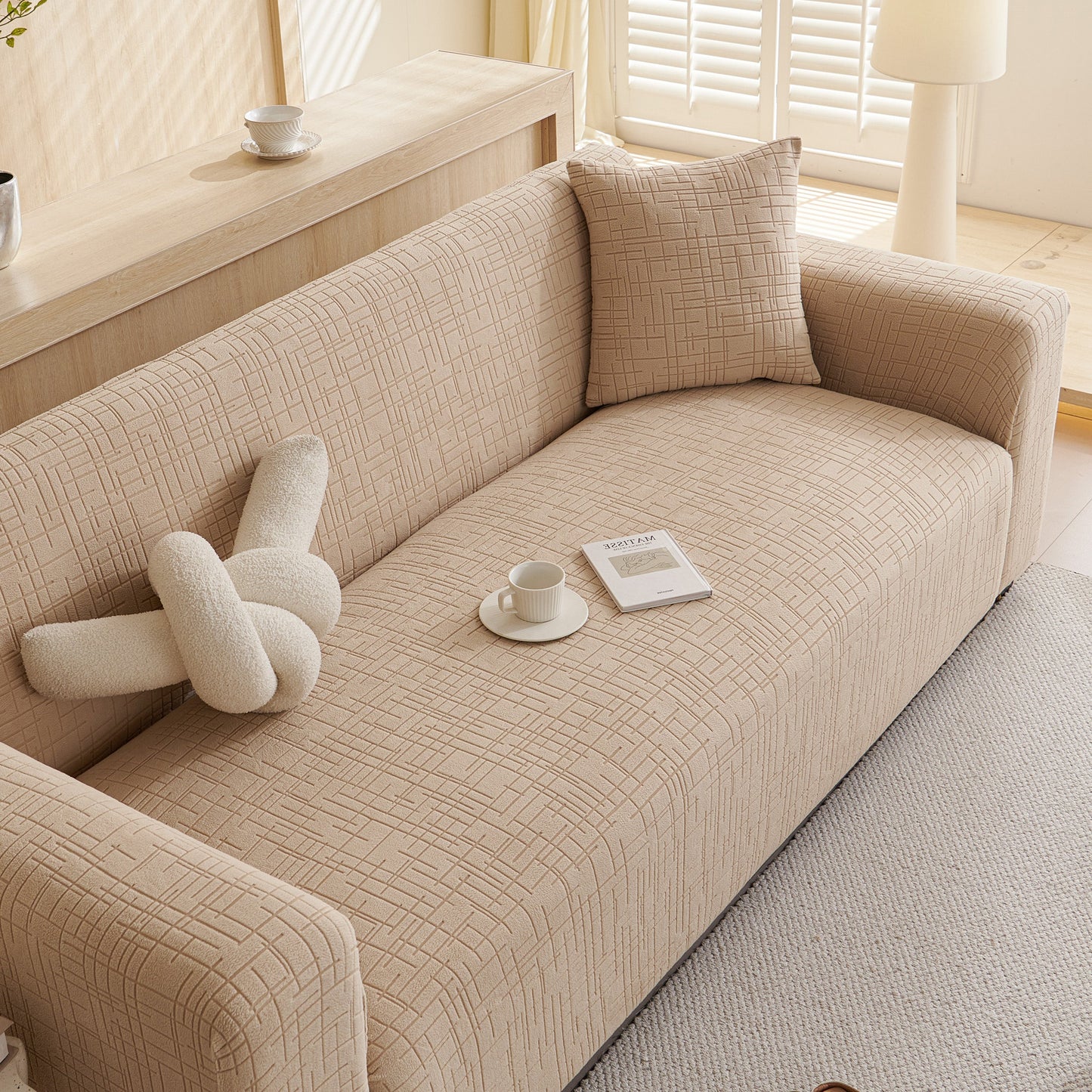Embossed Lines Couch Covers Stretchable Non-Slip & Washable Sofa Slipcovers on a beige sofa in a living room setting with soft lighting.