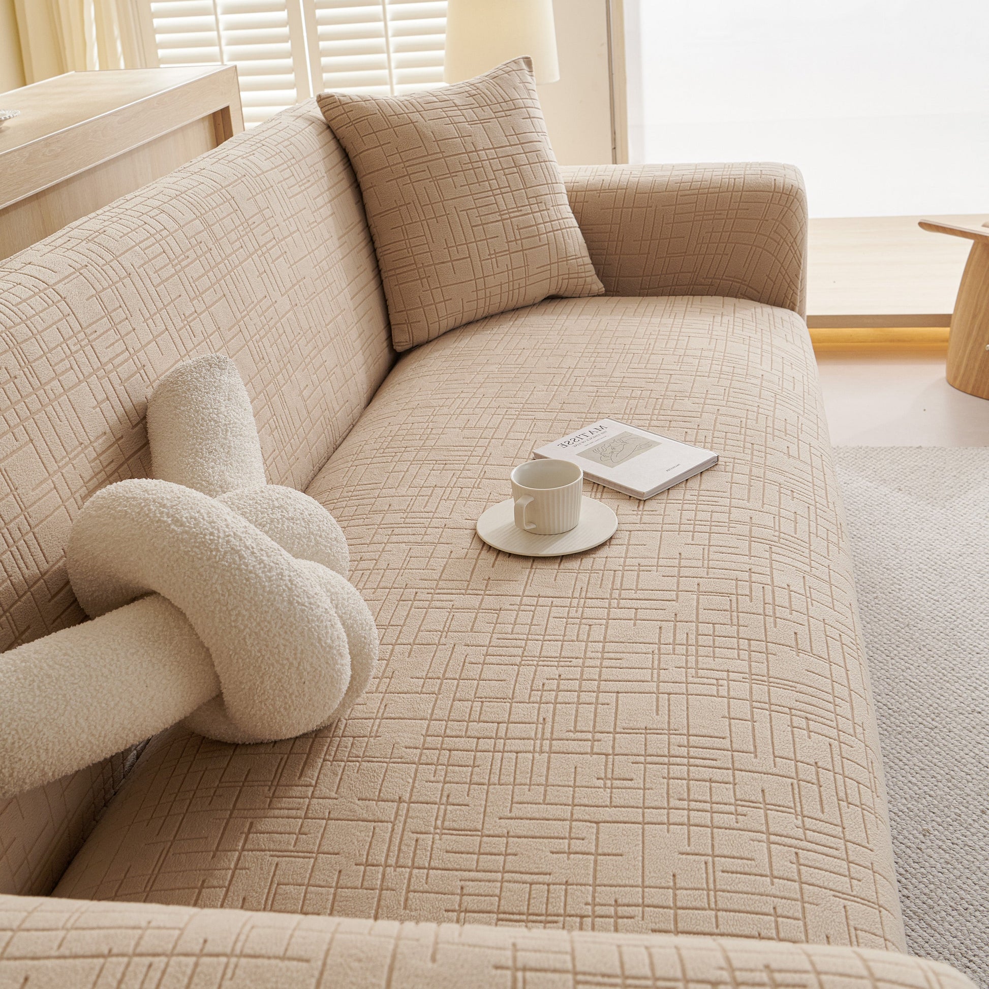 Embossed Lines Couch Covers Stretchable Non-Slip & Washable Sofa Slipcovers on beige couch with coffee and book