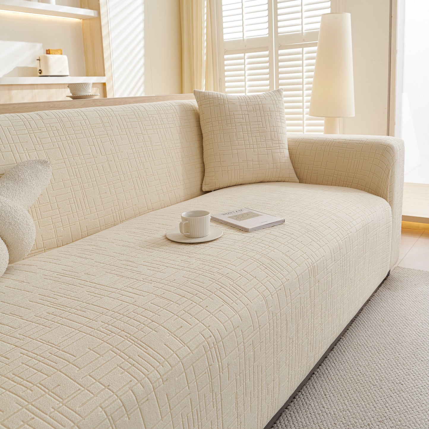 Cream-colored sofa with Embossed Lines Couch Covers Stretchable Non-Slip & Washable Sofa Slipcovers in a cozy living room setting.