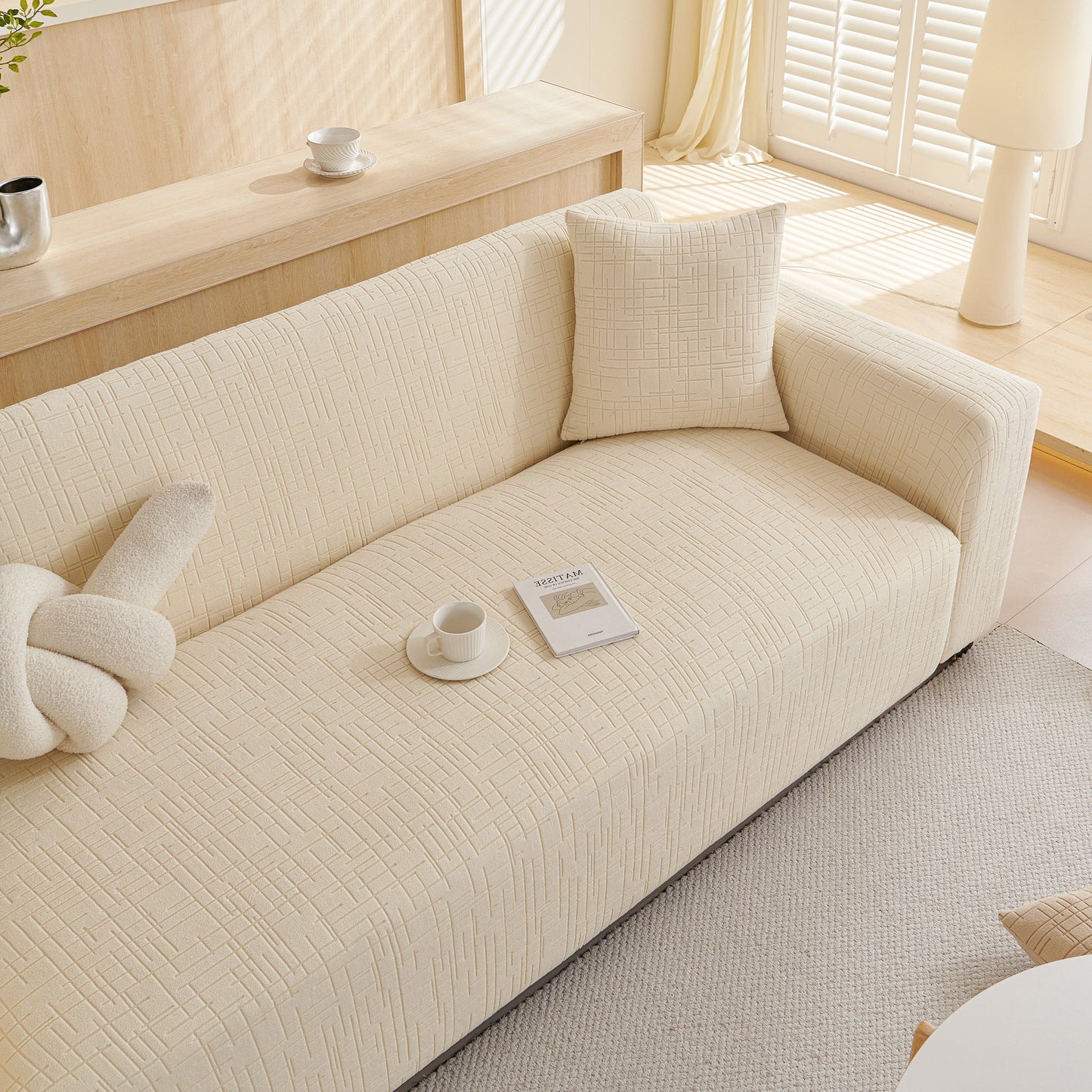 Embossed Lines Couch Covers Stretchable Non-Slip & Washable Sofa Slipcovers on a modern beige couch in a sunlit living room.