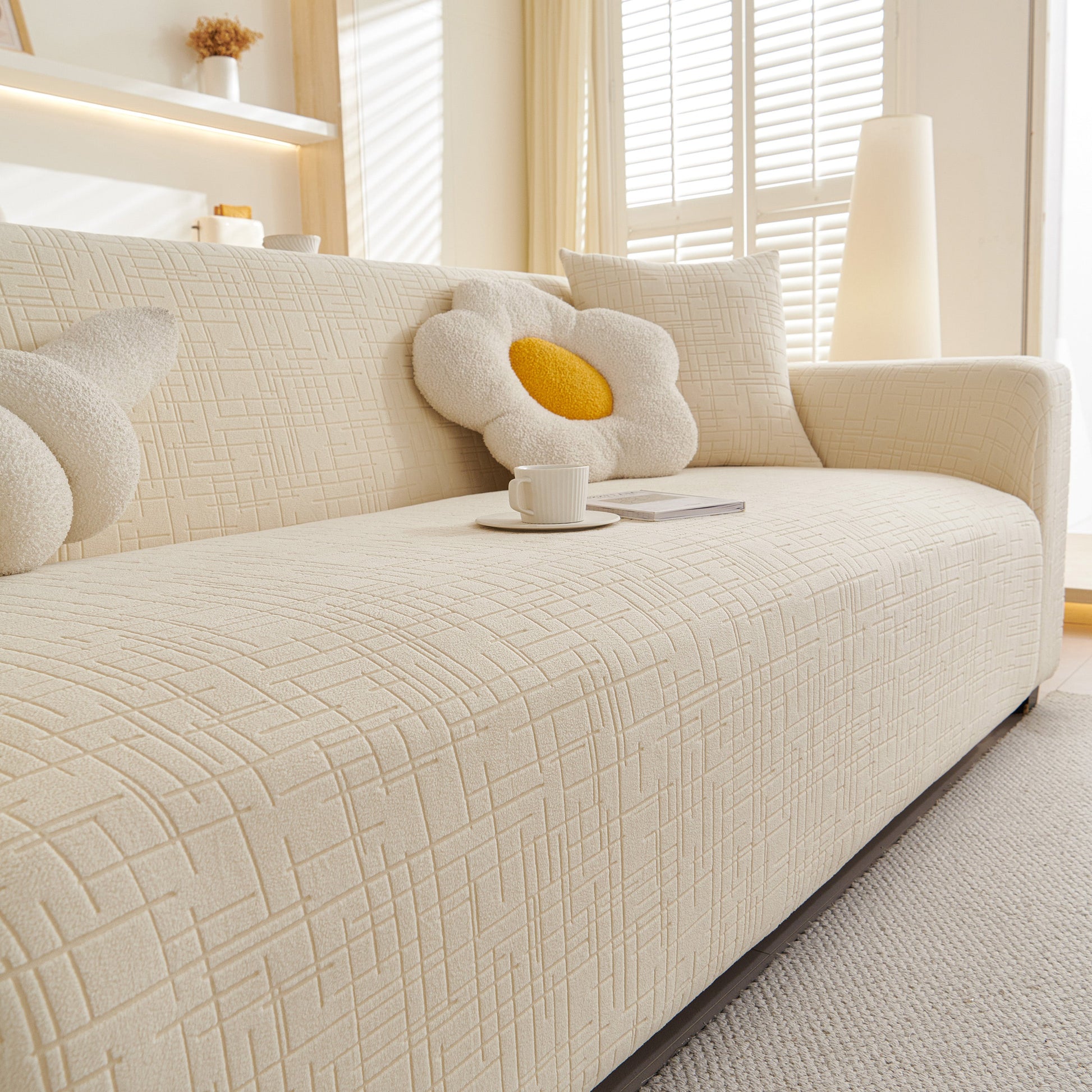 Embossed Lines Couch Covers Stretchable Non-Slip & Washable Sofa Slipcovers on beige sofa with floral cushions in bright living room.