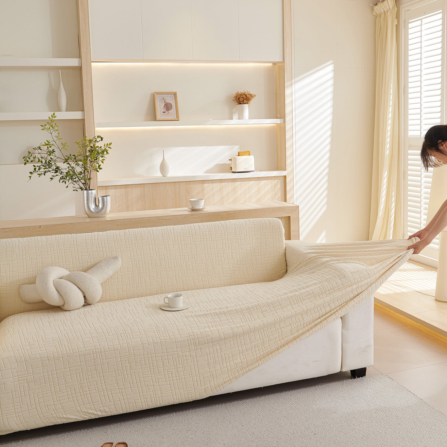 Woman adjusting Embossed Lines Couch Covers Stretchable Non-Slip & Washable Sofa Slipcovers in a living room