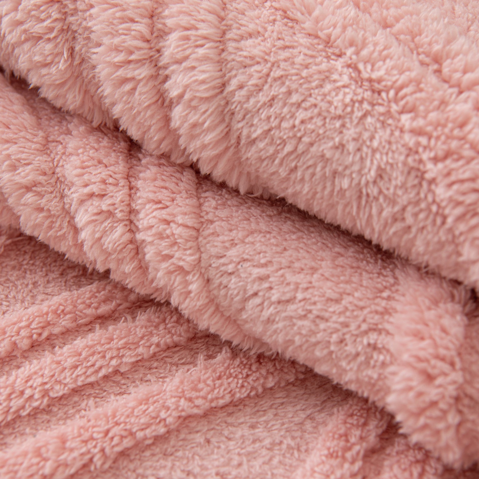 Close-up of a Winter Thickened Non-slip Blanket, Three-Dimensional Embossed Cotton Velvet Sofa Cover in soft pink color.