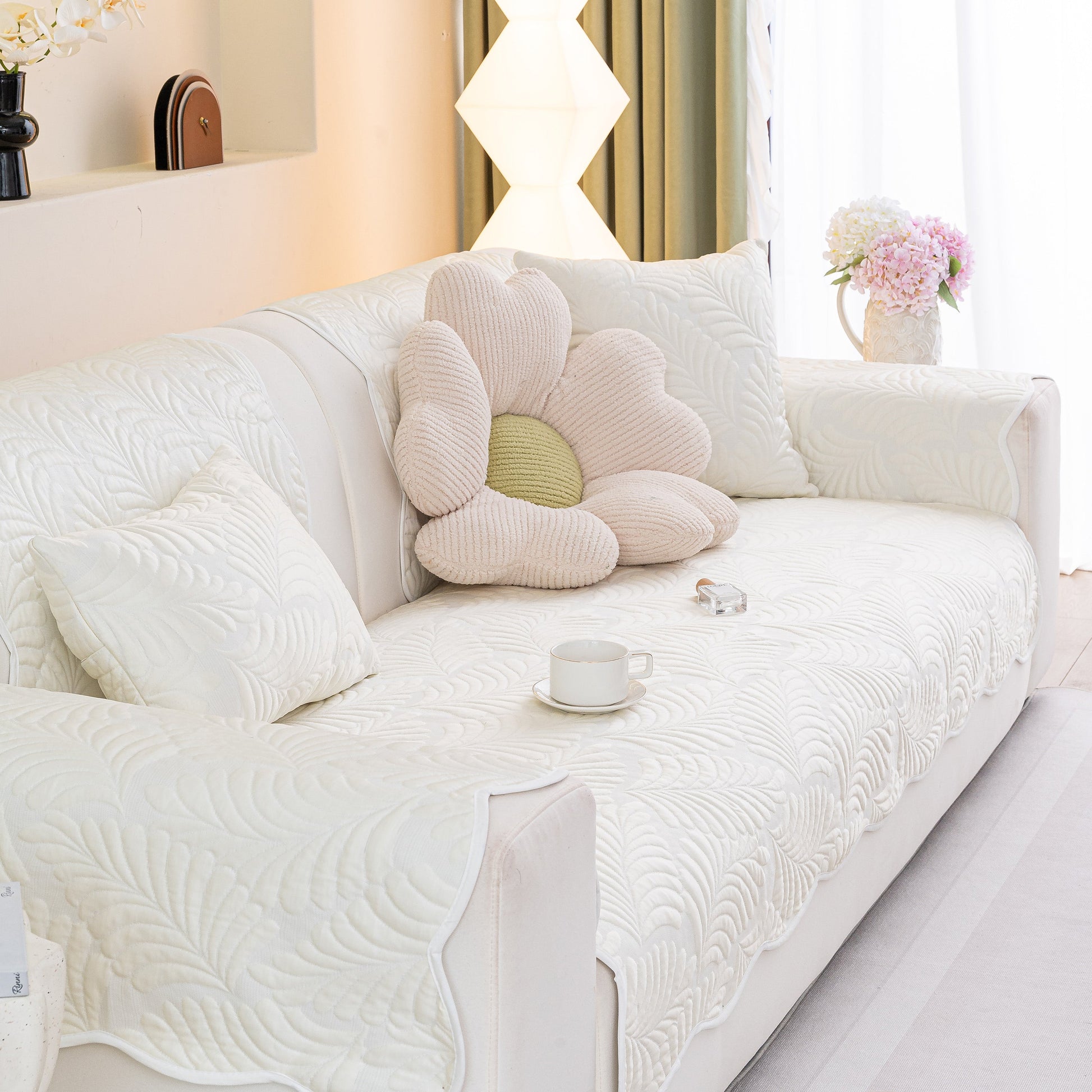 Sofa Cover for Leather & Fabric Couches, 3D Leaf Embossed Quilted Furniture Covers on a white sofa with a floral pillow.