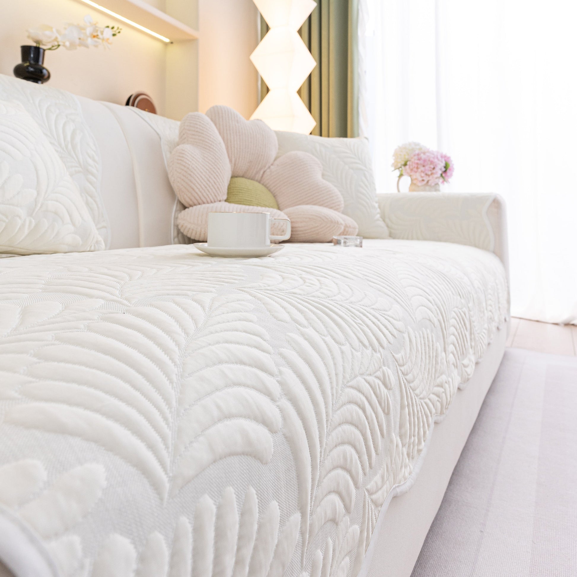 Sofa Cover for Leather & Fabric Couches, 3D Leaf Embossed Quilted Furniture Covers with anti-slip backing on a white couch.