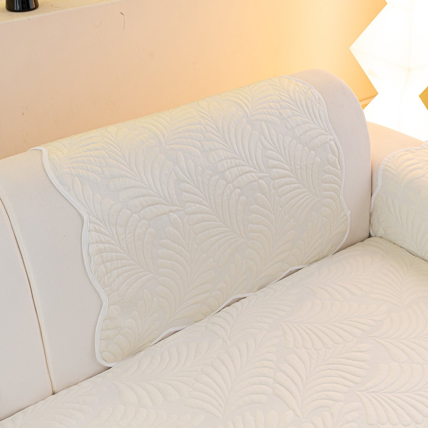 Sofa Cover for Leather & Fabric Couches, 3D Leaf Embossed Quilted Furniture Covers on a white couch, showcasing anti-slip design.