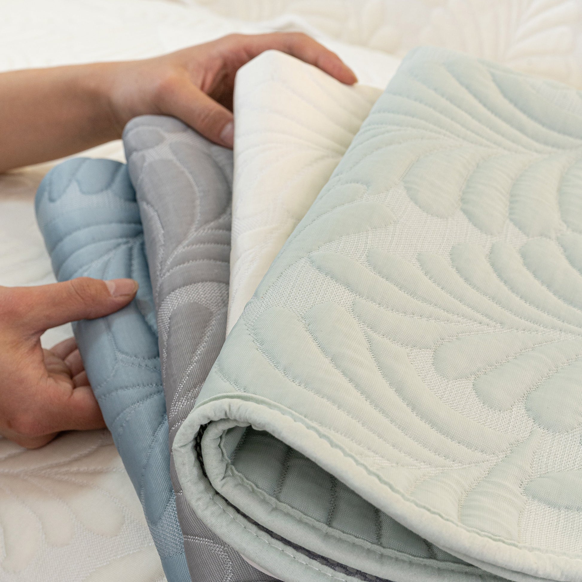 Hands holding 3D Leaf Embossed Quilted Furniture Covers for Leather & Fabric Couches, showcasing the detailed design and materials.