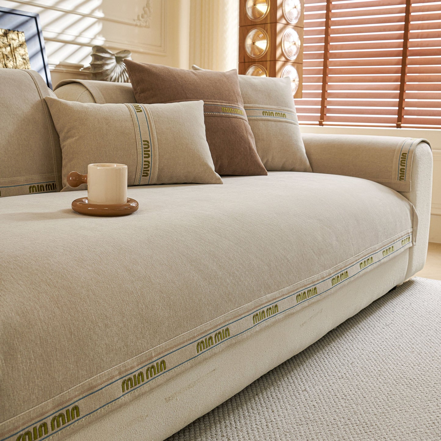Chenille Sofa Cover Pet Mat, Non-Slip Couch Protector for Sectional & L-Shaped Sofas on a beige couch with pillows in a living room.