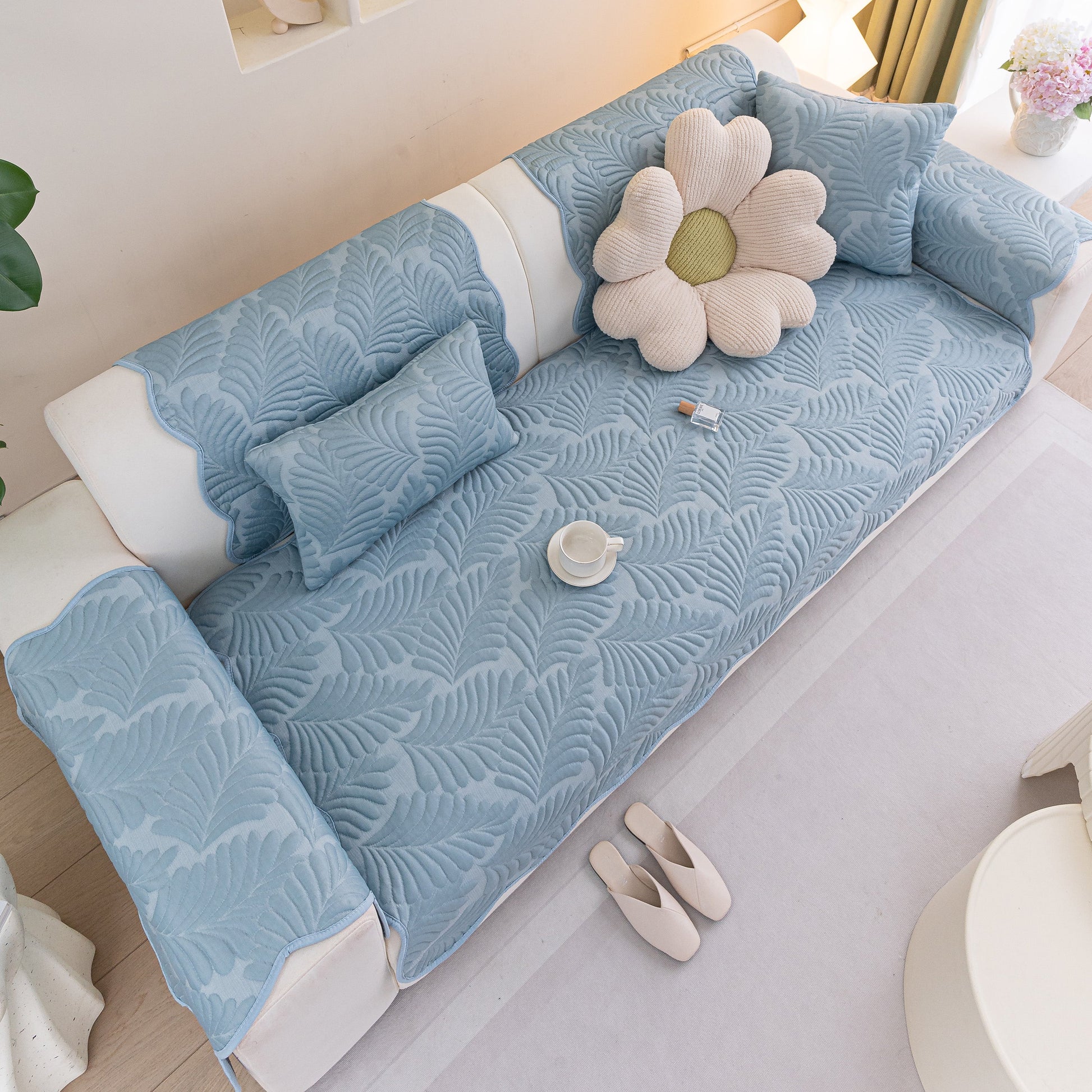 Sofa Cover for Leather & Fabric Couches, 3D Leaf Embossed Quilted Furniture Covers in blue on a white sofa with decorative cushions