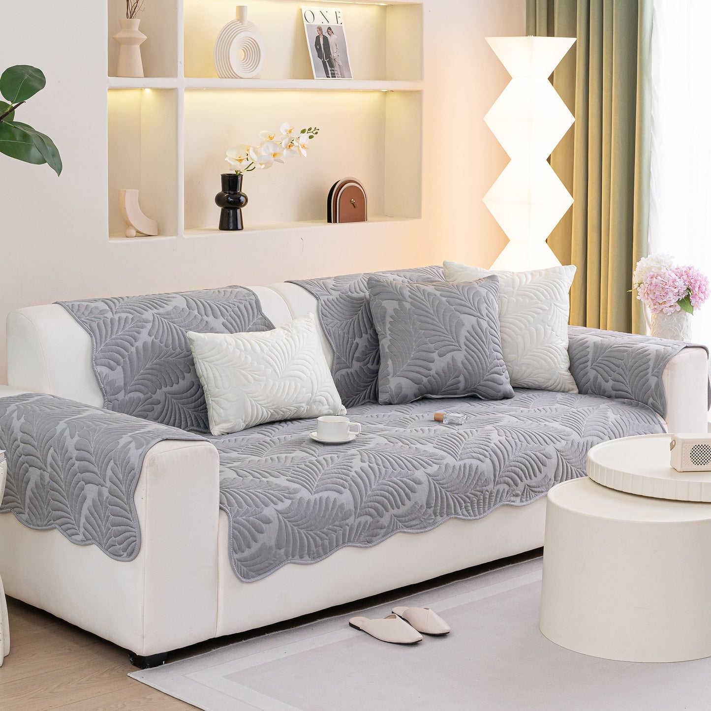 Sofa Cover for Leather & Fabric Couches, 3D Leaf Embossed Quilted Furniture Covers on a white sofa in a living room setting.