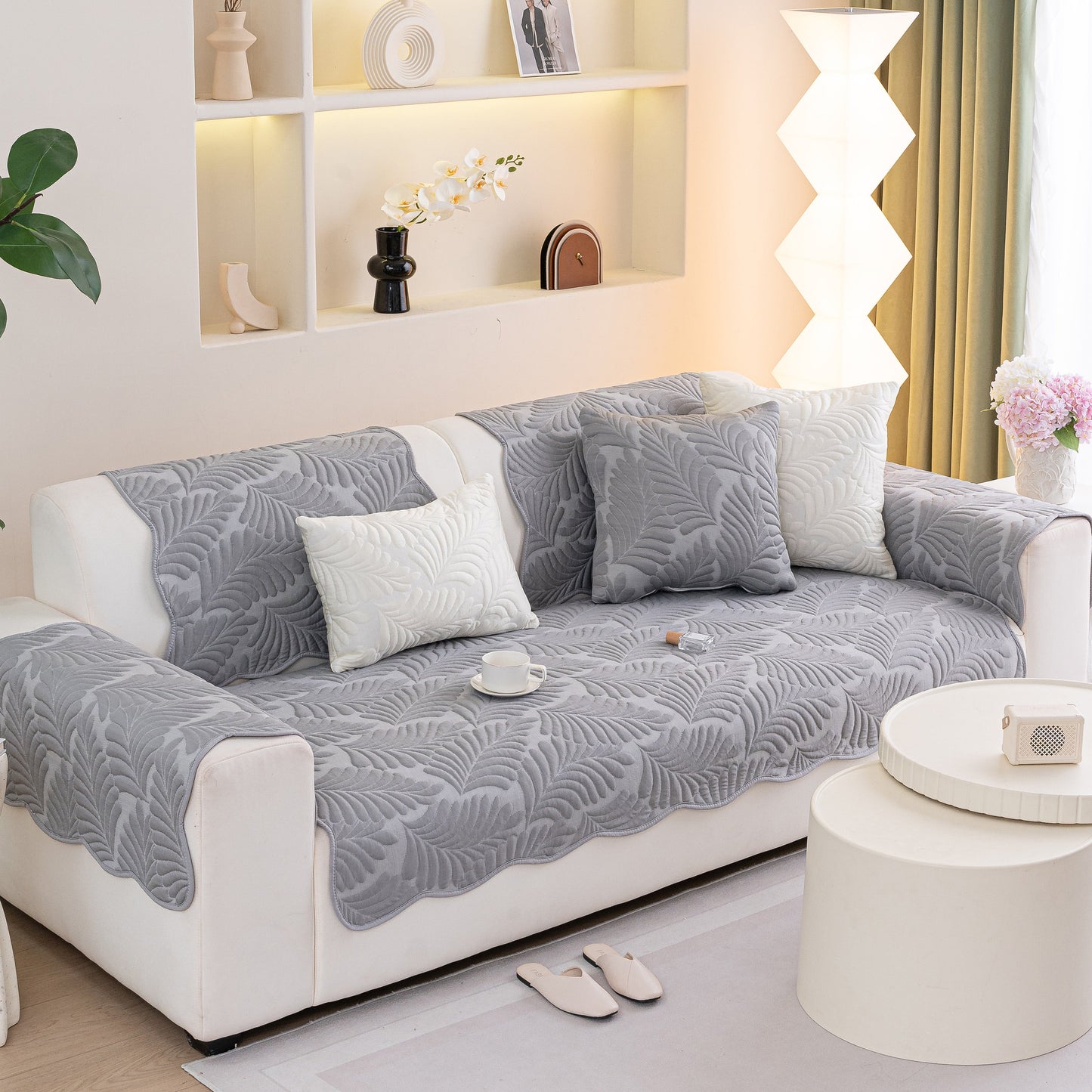 Sofa Cover for Leather & Fabric Couches, 3D Leaf Embossed Quilted Furniture Covers on a couch in a living room setting.