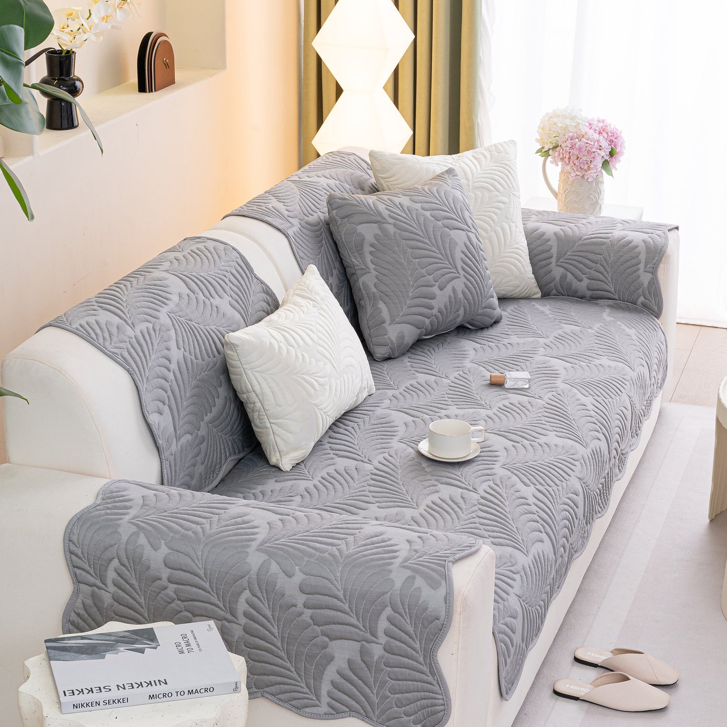 Sofa Cover for Leather & Fabric Couches, 3D Leaf Embossed Quilted Furniture Covers displayed on a couch in a stylish living room.