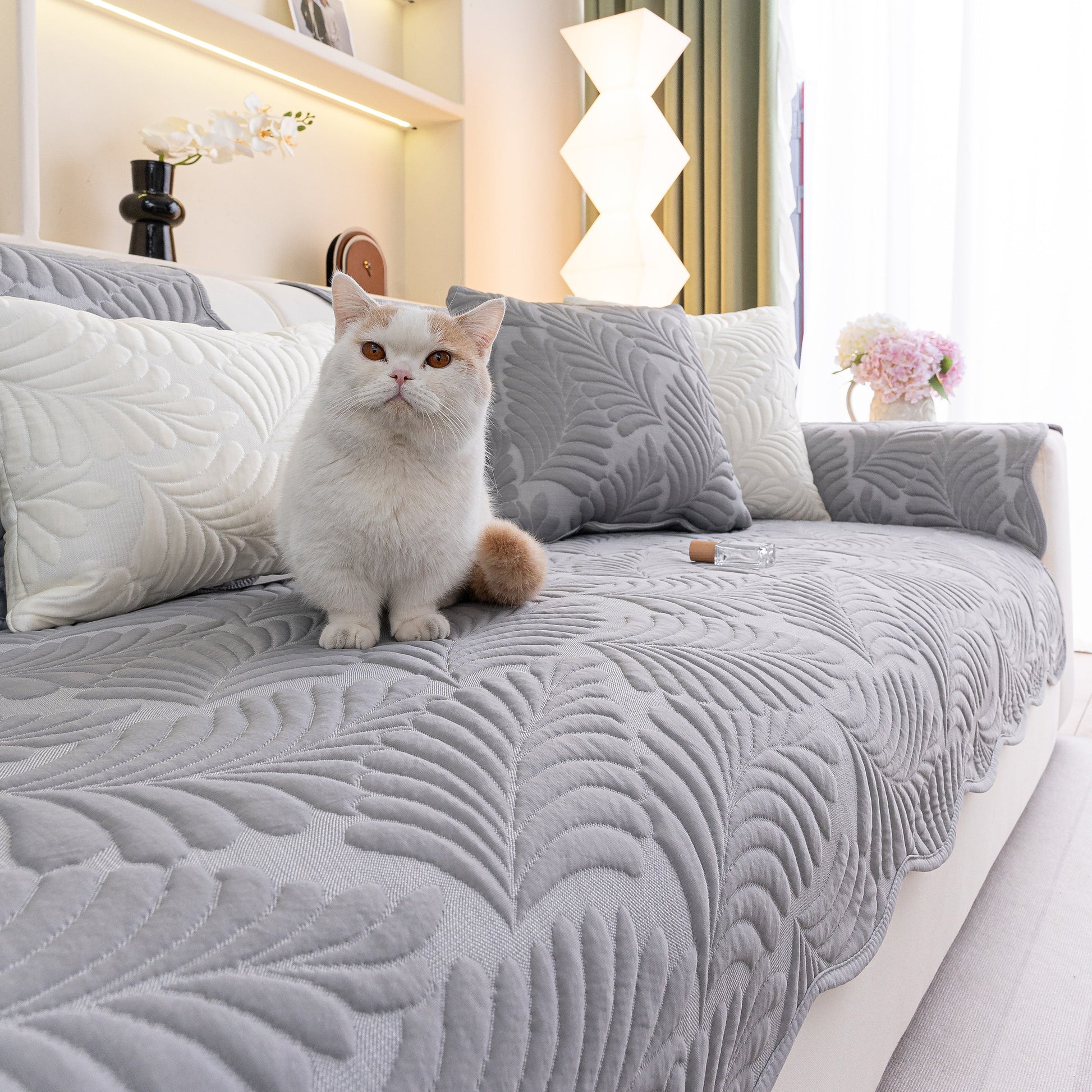 Sofa Cover for Leather & Fabric Couches, 3D Leaf Embossed Quilted Furniture Covers shown with a cat on a grey sofa.