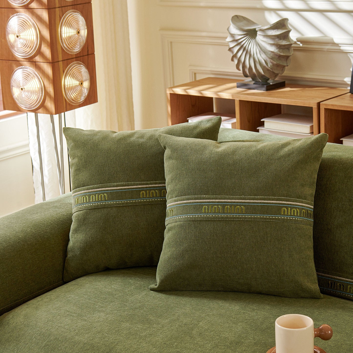 Stylish modern living room with decorative pillows on a green fabric sofa