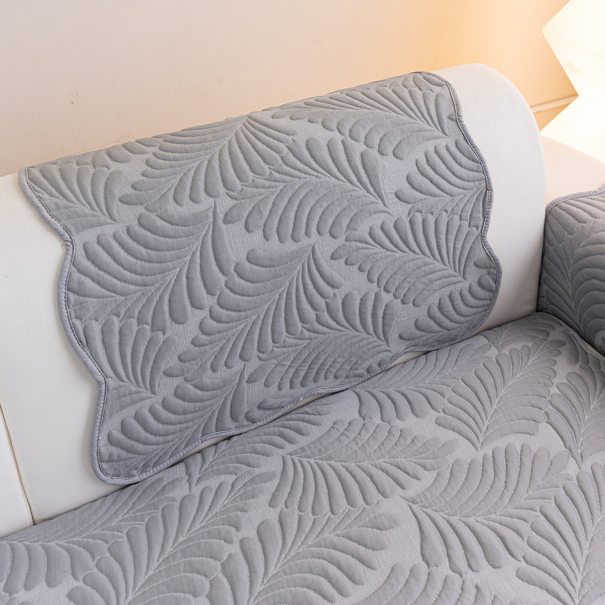Sofa Cover for Leather & Fabric Couches, 3D Leaf Embossed Quilted Furniture Covers with wave-cut edges displayed on a couch