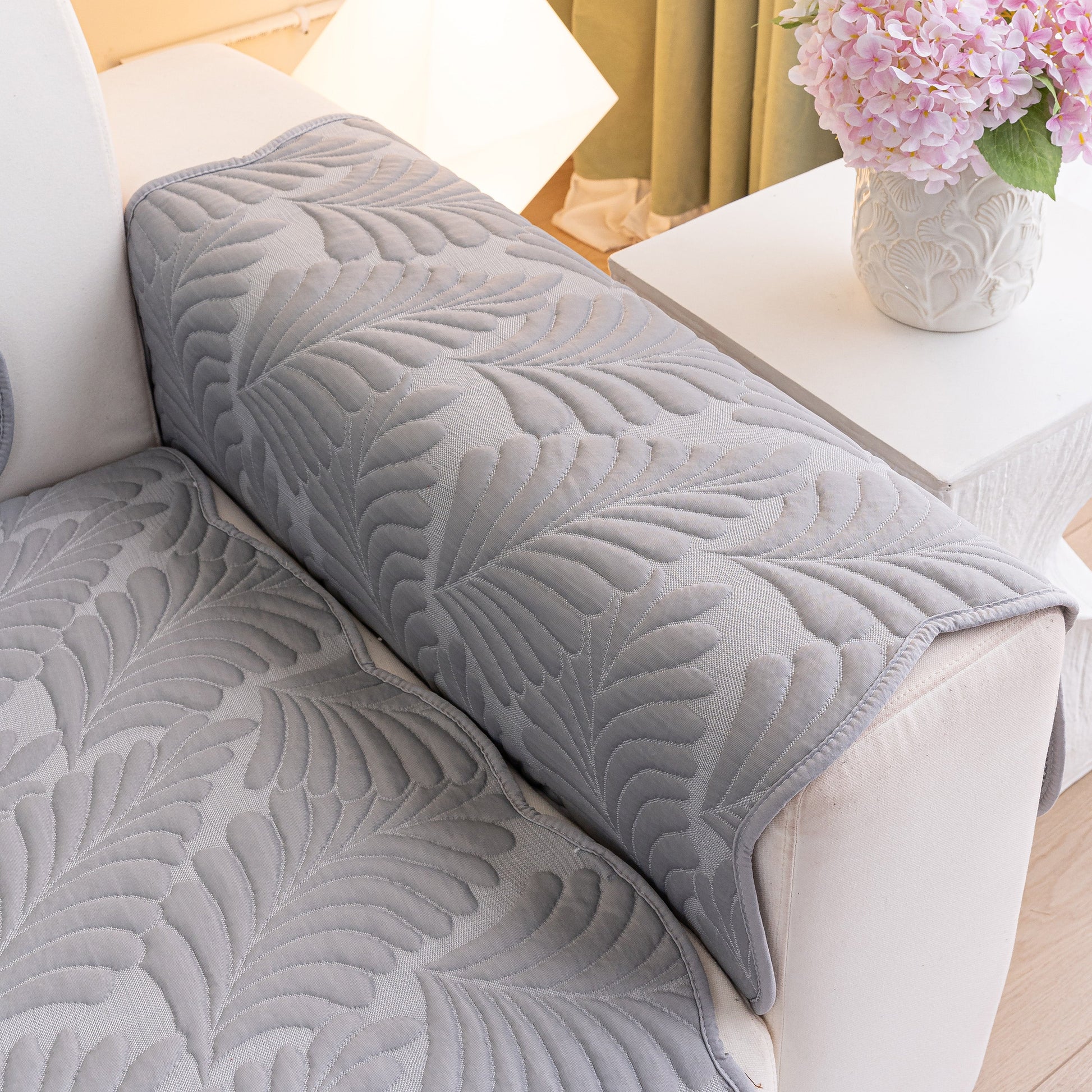 Sofa Cover for Leather & Fabric Couches, 3D Leaf Embossed Quilted Furniture Covers on a couch showing wave-cut edges and anti-slip backing.