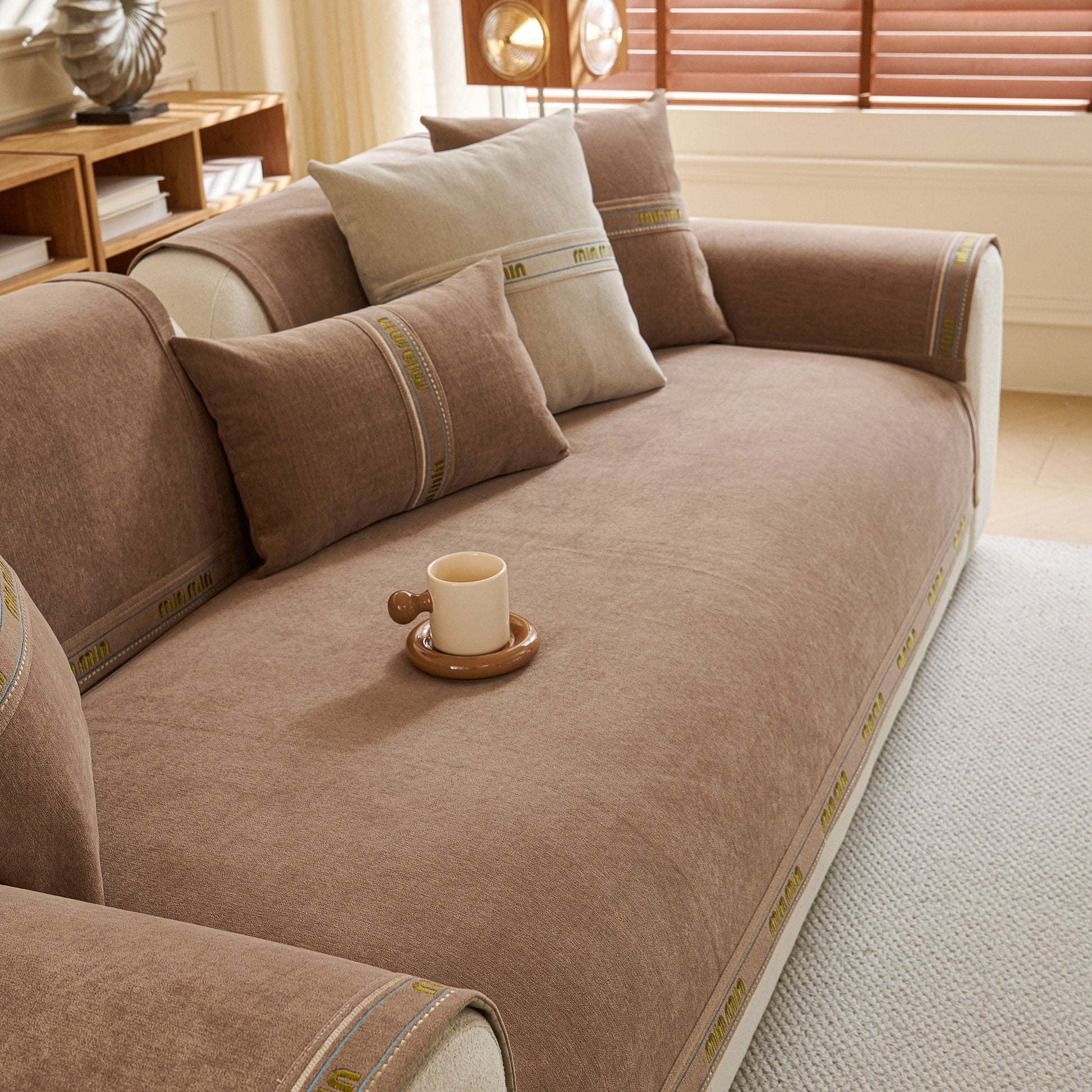Chenille Sofa Cover Pet Mat with beige and brown design, non-slip couch protector for sectional and L-shaped sofas, coffee cup on sofa.