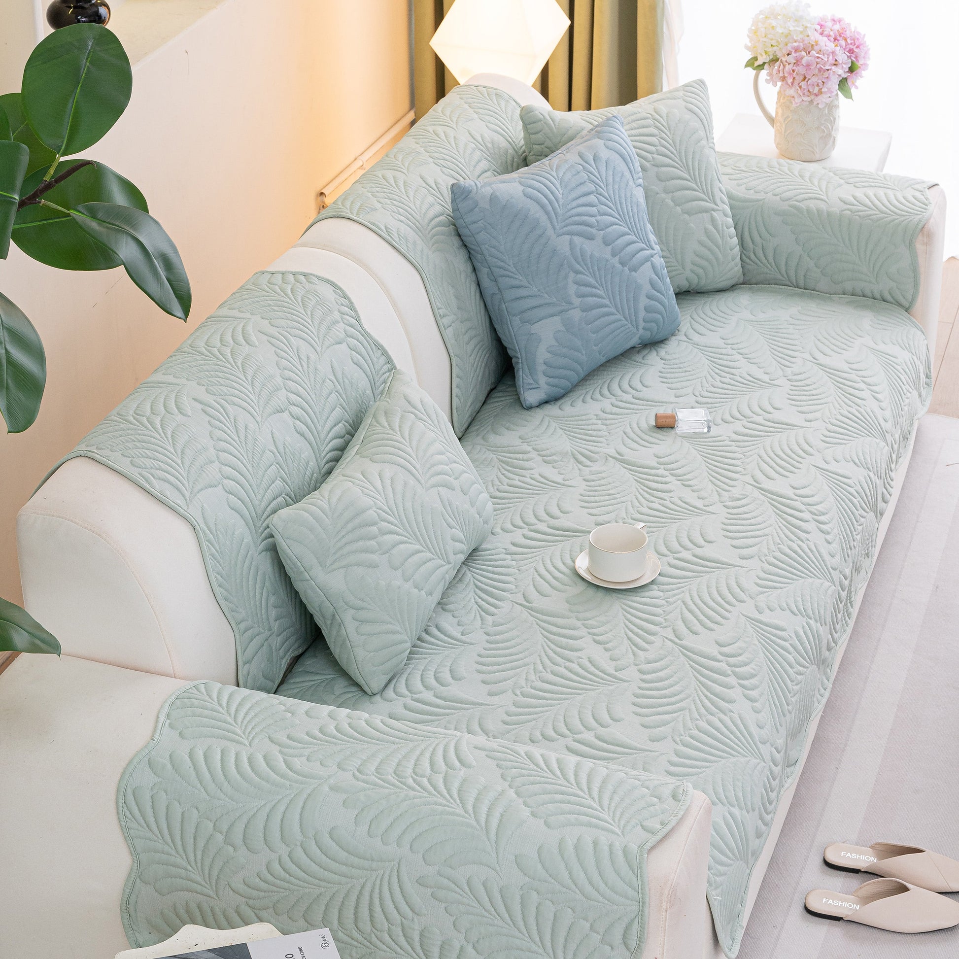 Sofa Cover for Leather & Fabric Couches, 3D Leaf Embossed Quilted Furniture Covers on a couch, showcasing its texture and fit.