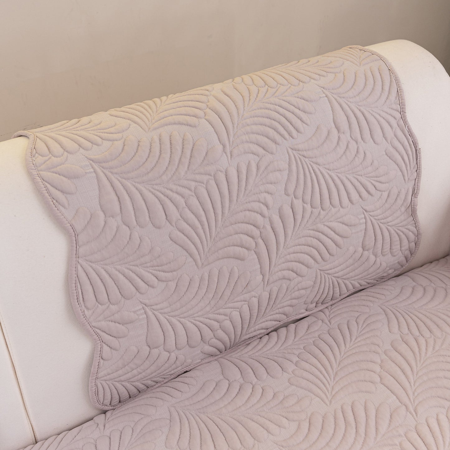 Sofa Cover for Leather & Fabric Couches, 3D Leaf Embossed Quilted Furniture Covers with anti-slip backing on a couch.