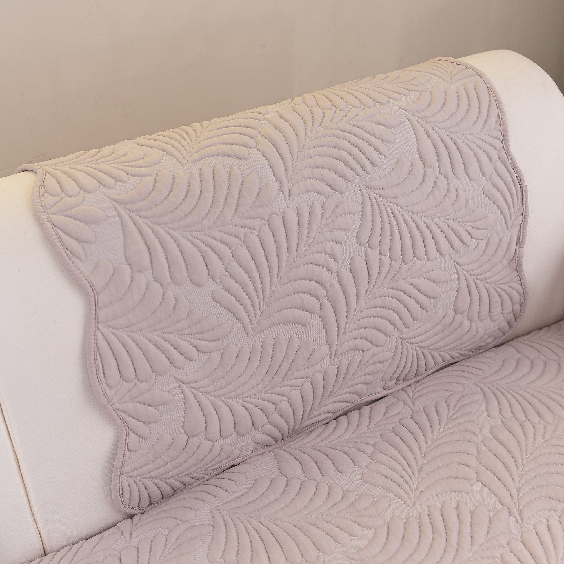 Sofa Cover for Leather & Fabric Couches, 3D Leaf Embossed Quilted Furniture Covers with anti-slip backing on a couch.