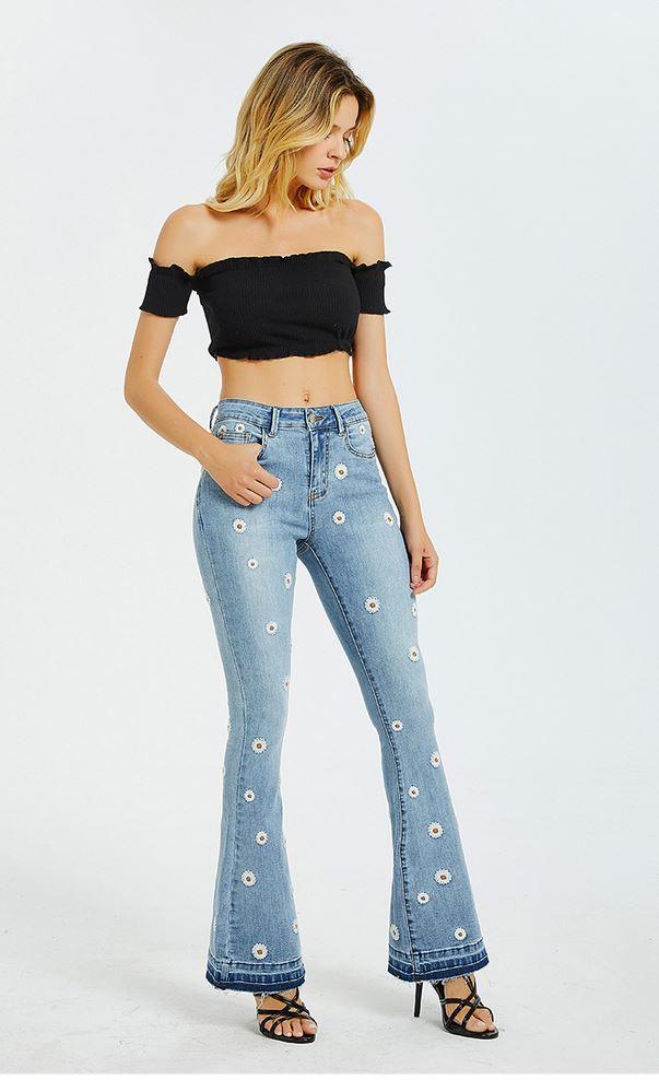 Model wearing Daisy Bloom Wide Leg Jeans with 3D daisy details, showcasing retro style and comfort in high-quality stretch denim.