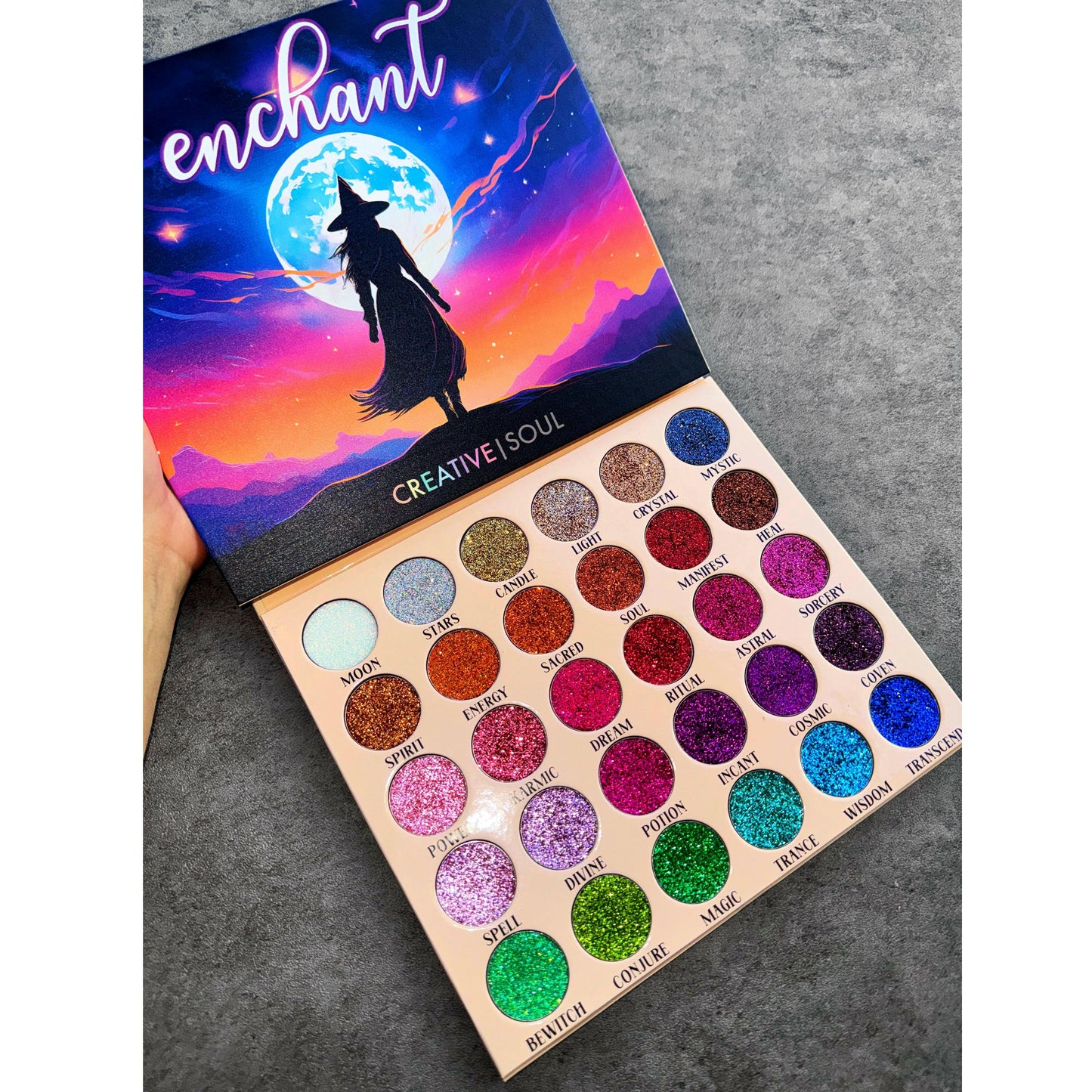 Enchant Pressed Glitter Eyeshadow Palette with vibrant creamy glitter shades in a magical night-themed package