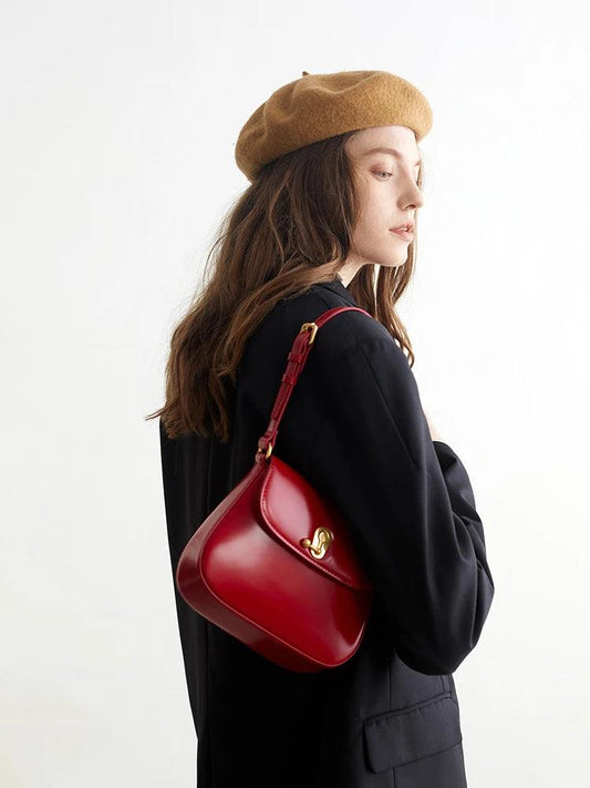Woman with red handbag wearing a beret and black coat