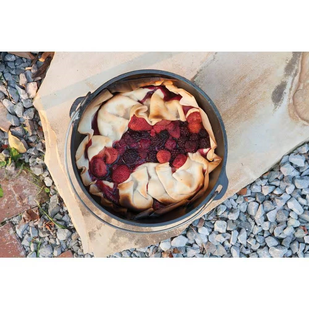 Fruit cobbler in 8-Quart Deep Seasoned Cast Iron Dutch Oven with Lid and Metal Handle on stones