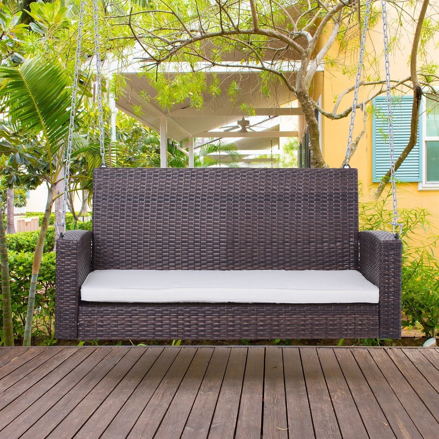 Espresso Wicker Porch Swing 7ft Hanging Chain with Cream Padded Cushion on porch.