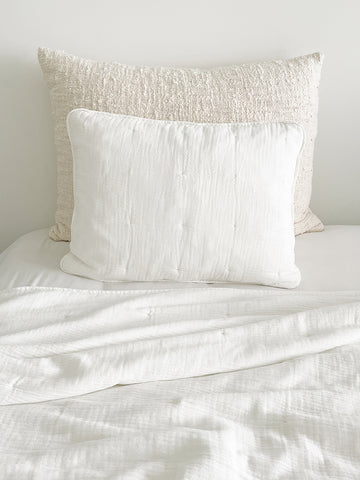Easy Cotton Gauze Quilt & Pillow Set in beige and white on a bed, showcasing lightweight comfort for hot summer nights.