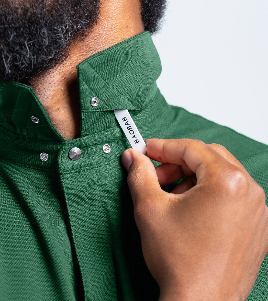 Close-up of Baobab Short Sleeve Perfect Polo with StaySharp™ Collar in green, demonstrating hidden snaps for a crisp look.