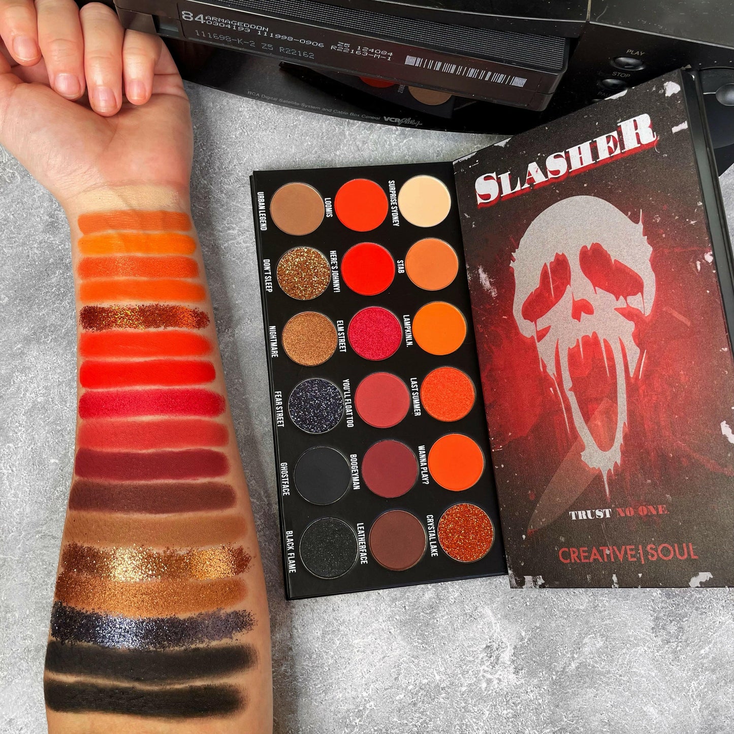 Slasher Eyeshadow Palette featuring vibrant horror-inspired shades swatched on arm, perfect for 90's VHS horror movie makeup lovers.