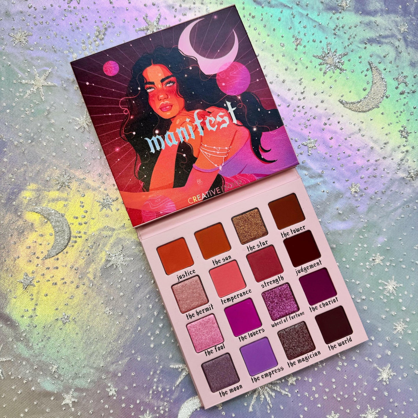 Manifest Eyeshadow Palette with 16 tarot-inspired shades including mattes and shimmers for pigmented, ethereal makeup looks.