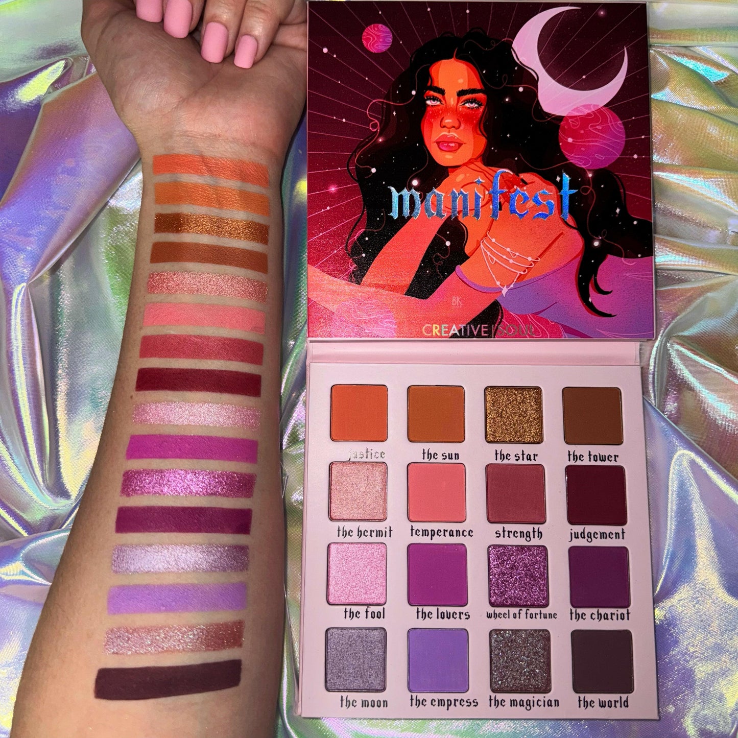 Manifest Eyeshadow Palette with tarot-inspired shades and swatches displayed on a holographic background.