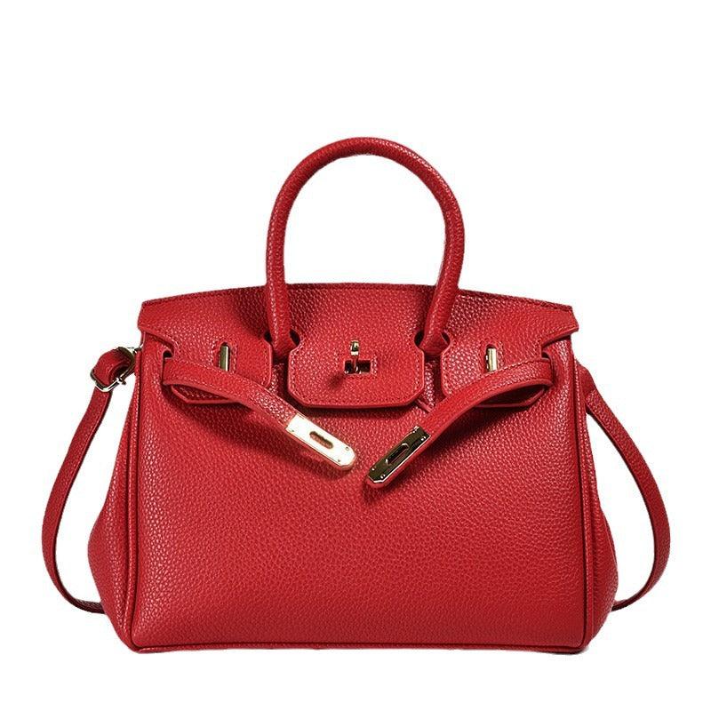 Red leather handbag with top handle and detachable shoulder strap on white background