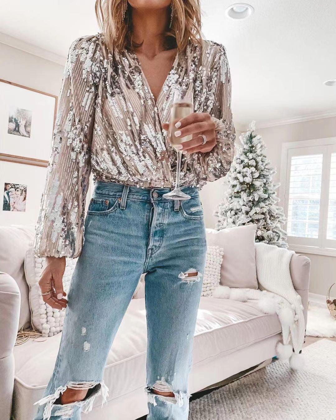 Woman wearing Sophisticated V-Neck Long Sleeved Sequin Top with a glass of champagne, perfect for a party or night out.