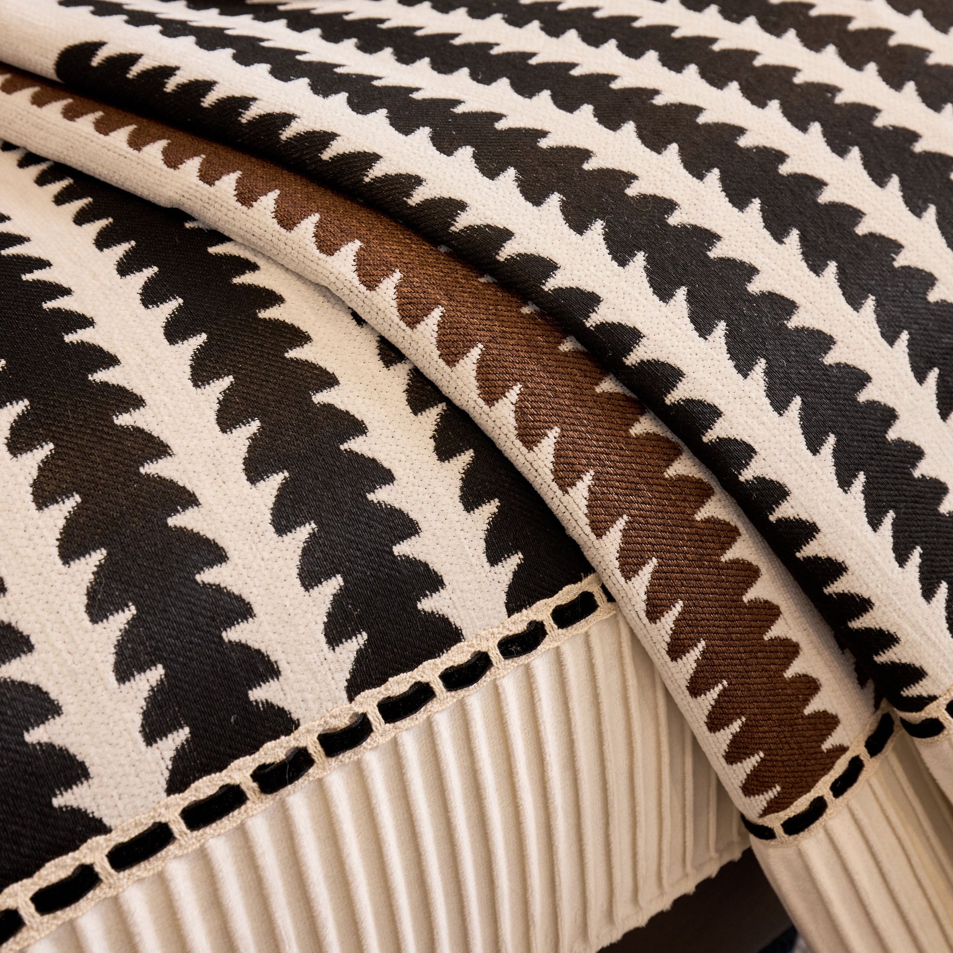 Close-up of textured fabric with black and brown geometric pattern, showcasing high-detail design and quality craftsmanship.