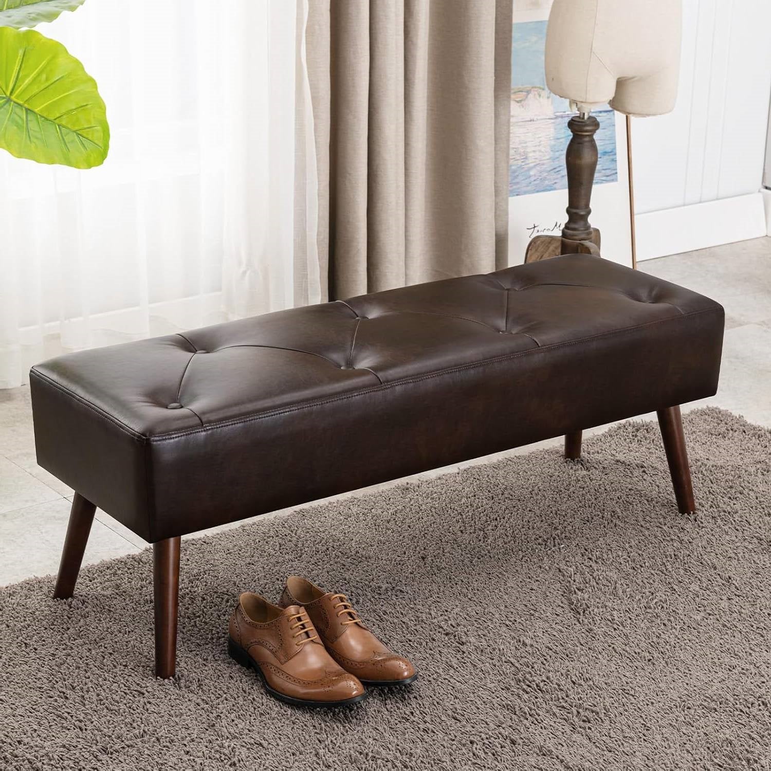 Mid-Century Bed Bench with Dark Brown Leather Upholstered Seat Solid Wood Legs on carpeted floor near shoes and lamp