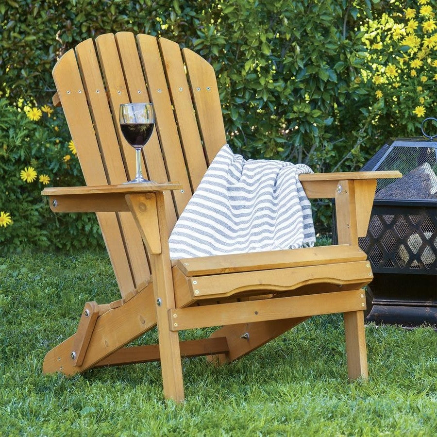 All Weather Adirondack Large Foldable Chair Natural Finish on lawn with wine glass and striped blanket.