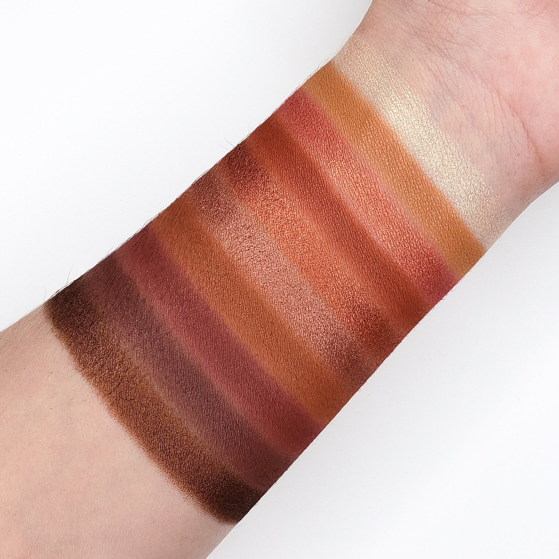 Crown Pro 10 Color Fuego Collection swatches showing five matte and five shimmer warm shades on arm, showcasing rich pigmentation.