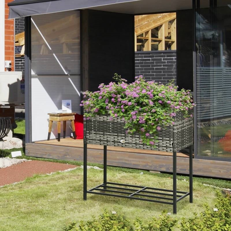 Grey Modern PE Rattan Wicker Raised Garden Bed Elevated Planter Box with purple flowers on a patio