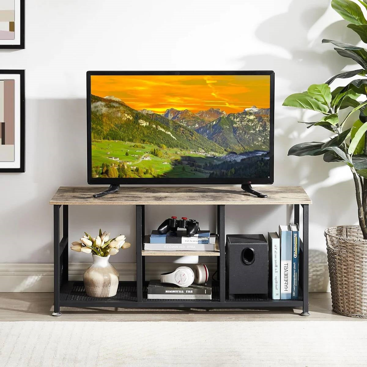Industrial Modern Black Metal Grey Wood TV Stand with Media Storage Shelf in a living room setting, holding a TV and decorations