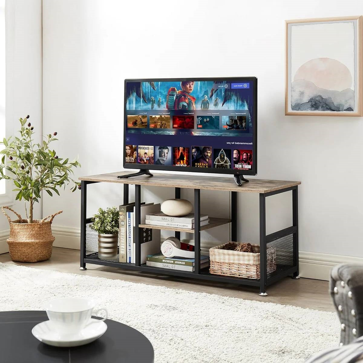Industrial Modern Black Metal Grey Wood TV Stand with Media Storage Shelf in living room setup with TV and decor items