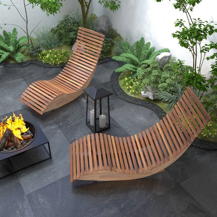 Curved wooden outdoor lounge chairs with a fire pit in a garden setting