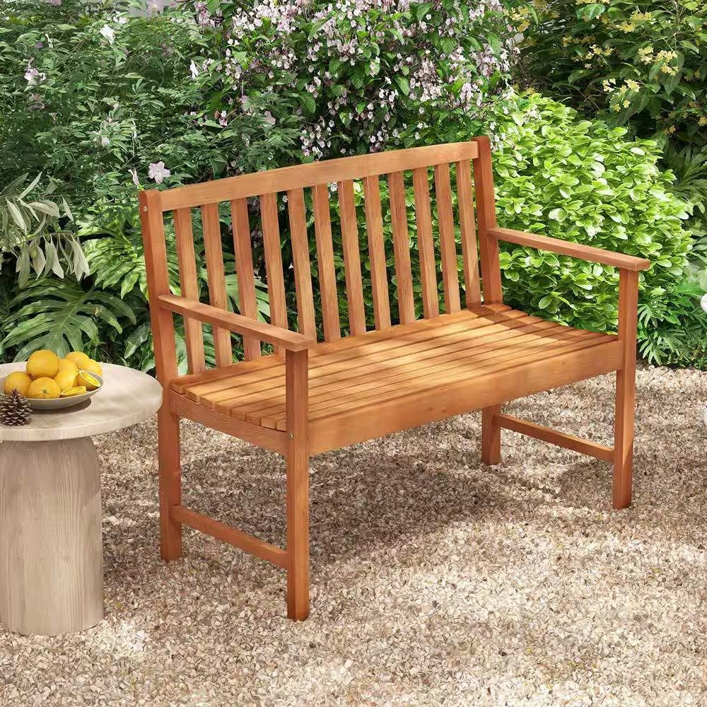 Solid Wood 4-Ft. Outdoor Patio Garden Bench - 800 lbs. Weight Capacity with armrests and backrest, set in a lush garden area.