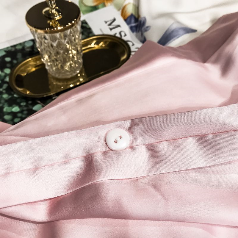 Close-up of Blossom Duvet Cover Set (Eucalyptus Lyocell) in soft pink with button detail, emphasizing luxury and elegance for bedroom decor.
