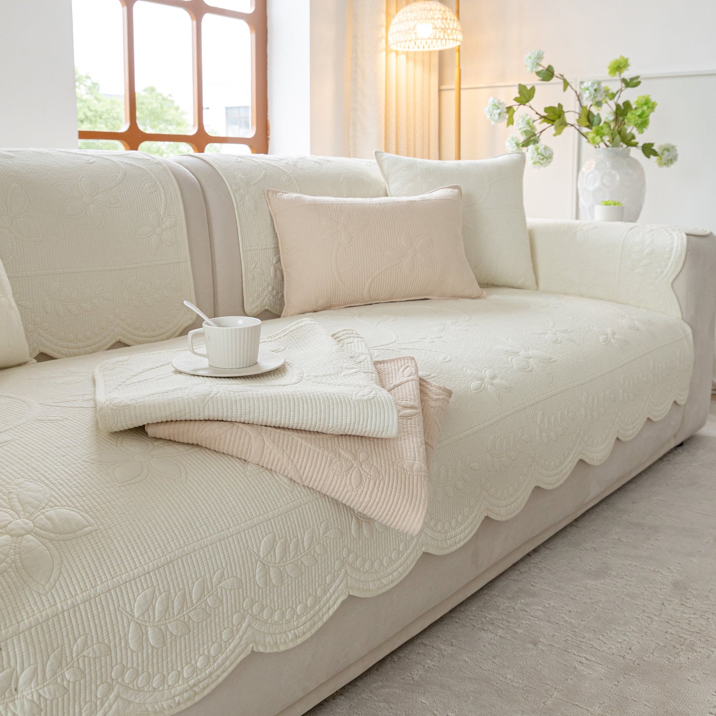 Floral Cotton Quilted Sofa Cover, Non-Slip Couch Protector with Scalloped Edges adding elegance to living room decor.