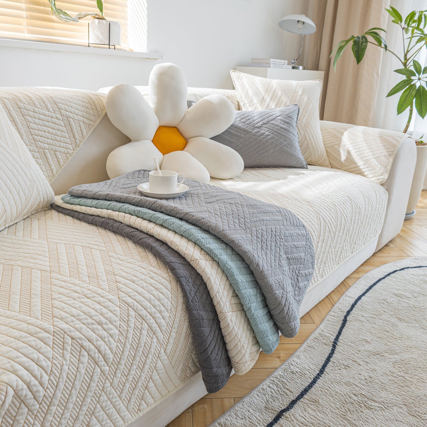 Quilted Geometric Cotton Sofa Cover, Non-Slip & Thick Padded Furniture Covers displayed on a sofa with decorative pillow and cup.